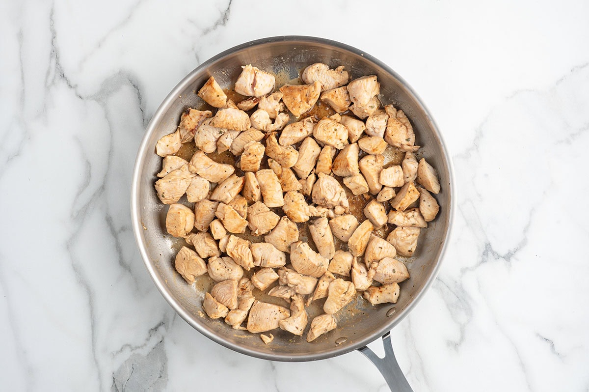 Cook the bite-sized chicken pieces in a skillet until golden brown and cooked through, stirring occasionally so they cook evenly.