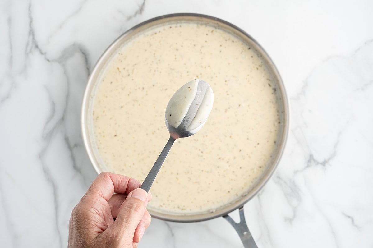 Simmer the creamy ranch sauce until it thickens enough to coat the back of a spoon.