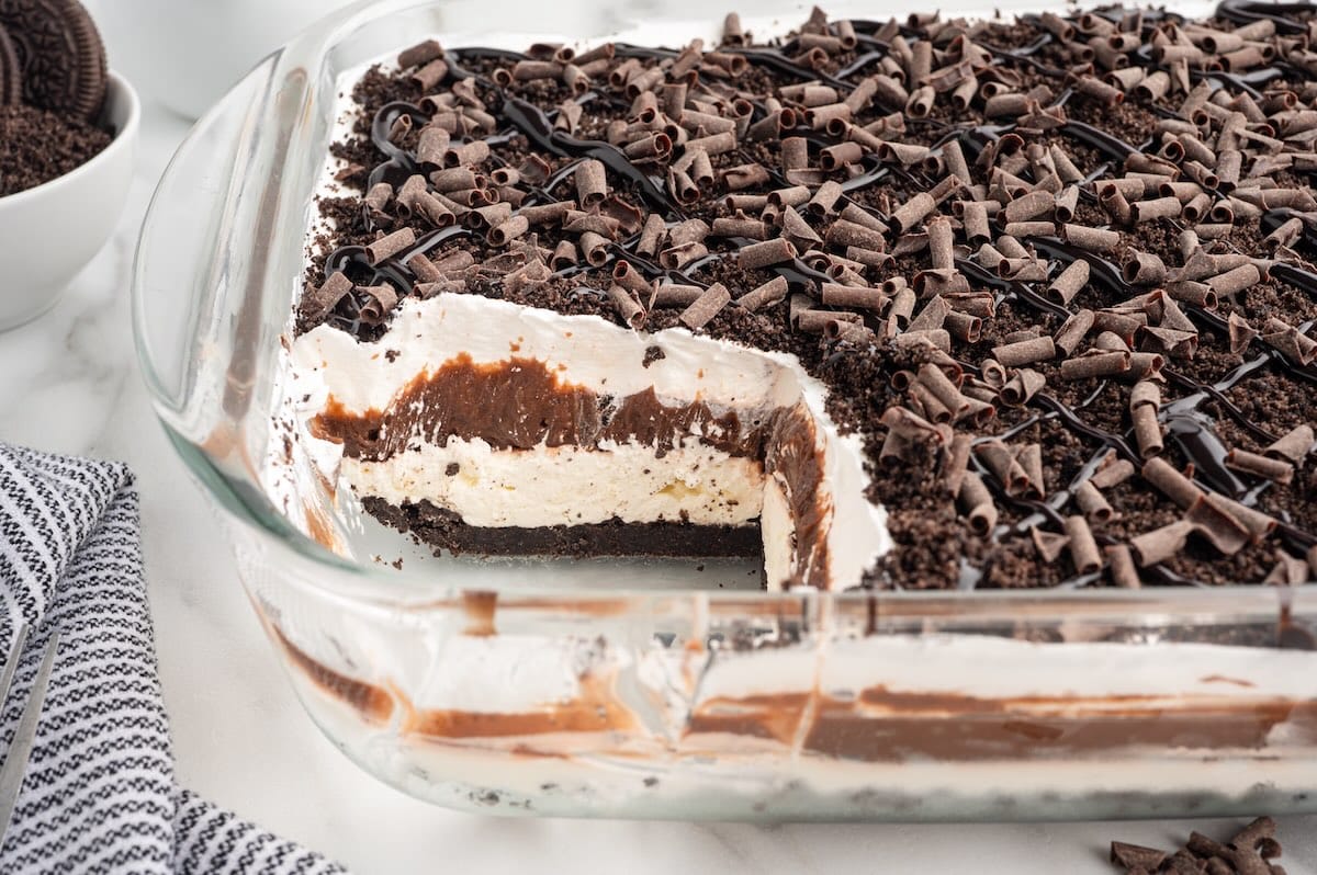 a pan of chocolate lasagna with a piece cut out showing the layers