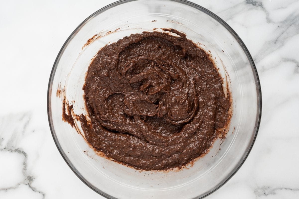 Chocolate pudding mixture swirled in a glass mixing bowl.