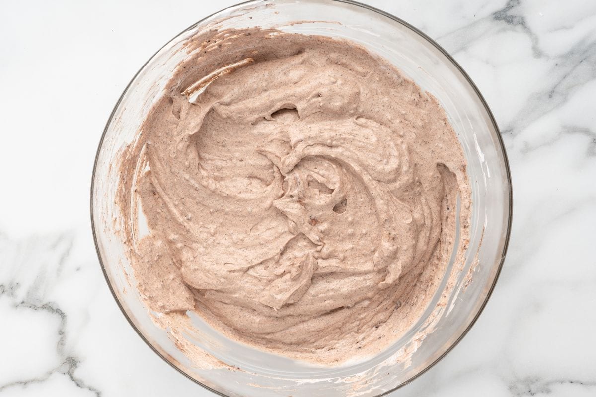 Whipped chocolate cream filling in a glass mixing bowl.