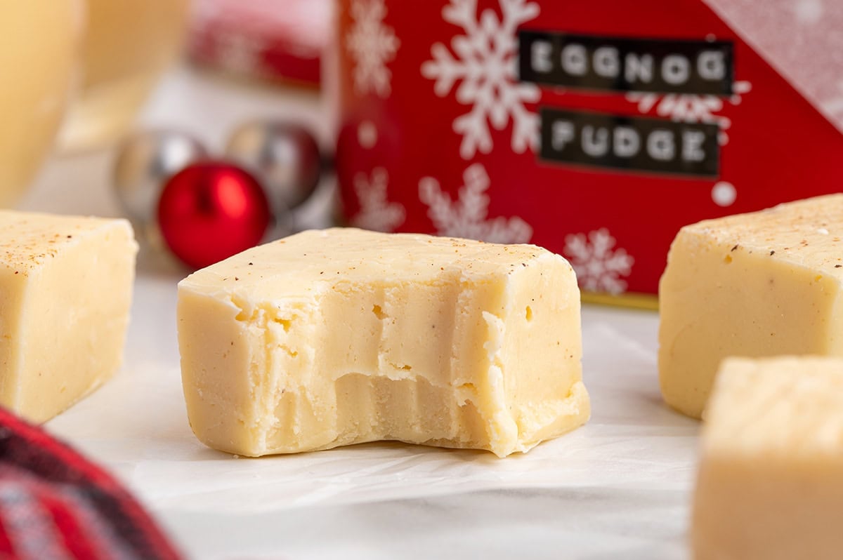 Eggnog fudge square with a bite taken out, lightly sprinkled with nutmeg.
