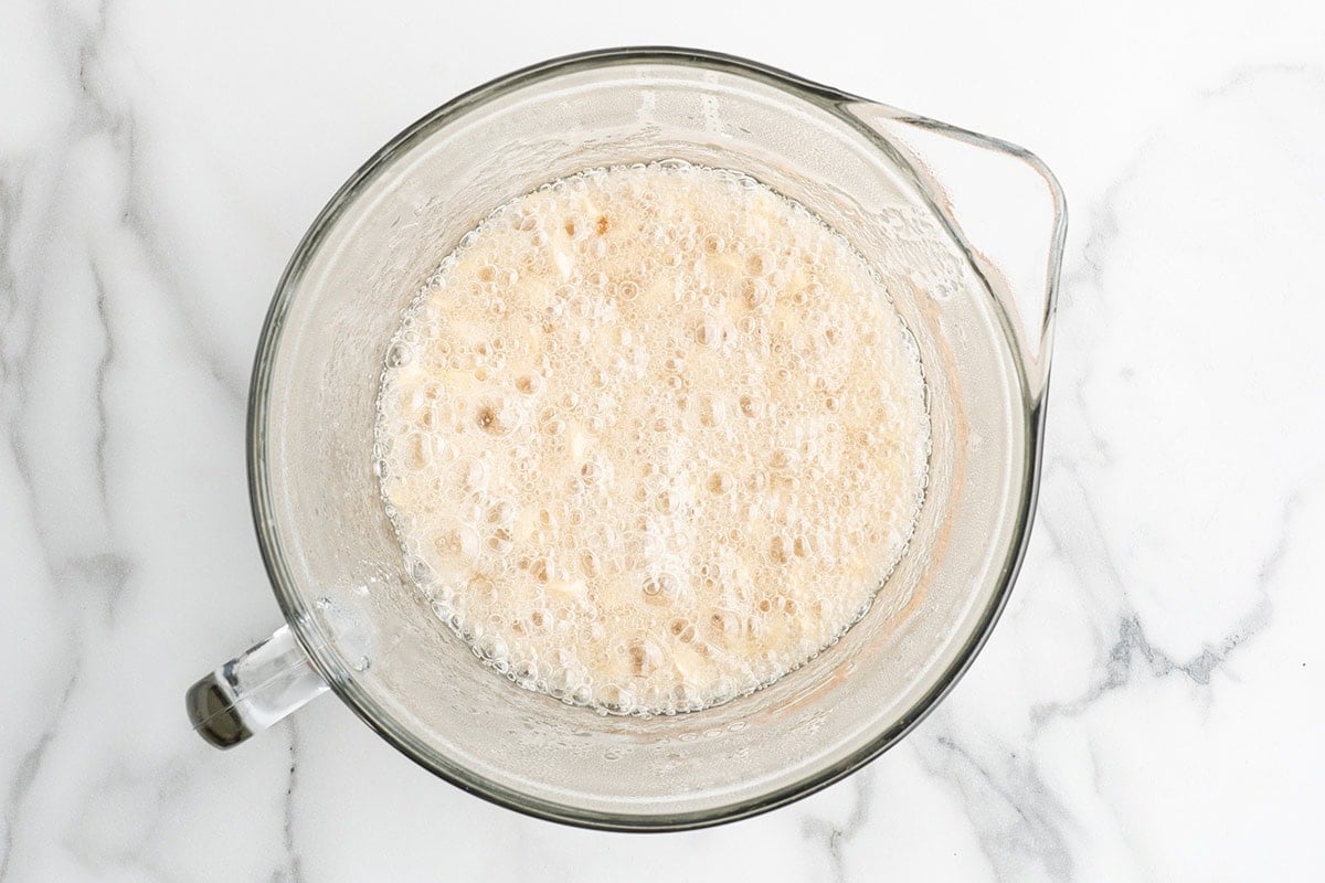 Bubbling peanut brittle mixture in a glass mixing bowl.