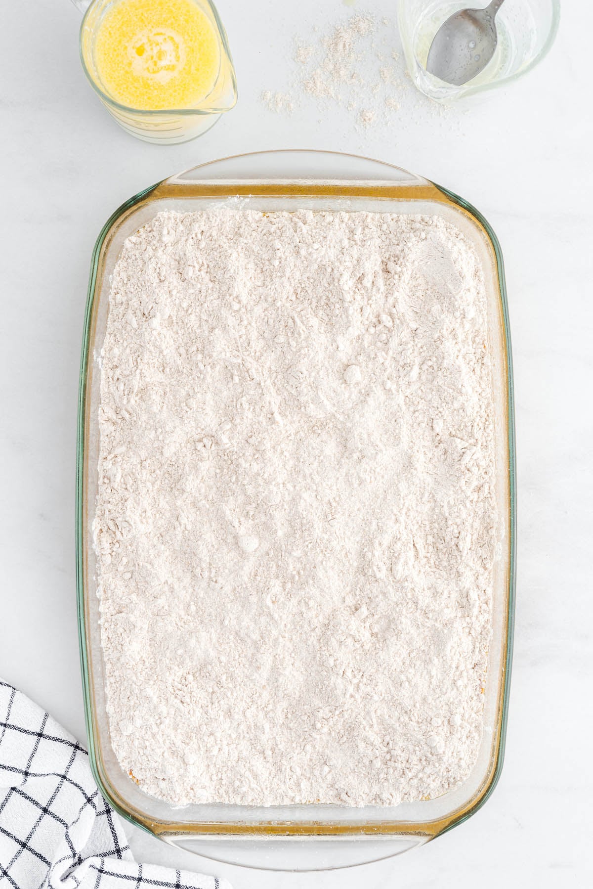 Pumpkin dump cake topped with an even layer of dry cake mix before baking.