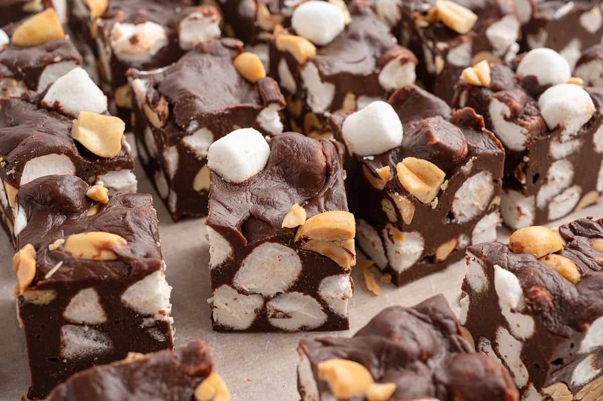 Close-up of Rocky Road Fudge squares loaded with mini marshmallows and crunchy peanuts in rich chocolate fudge.