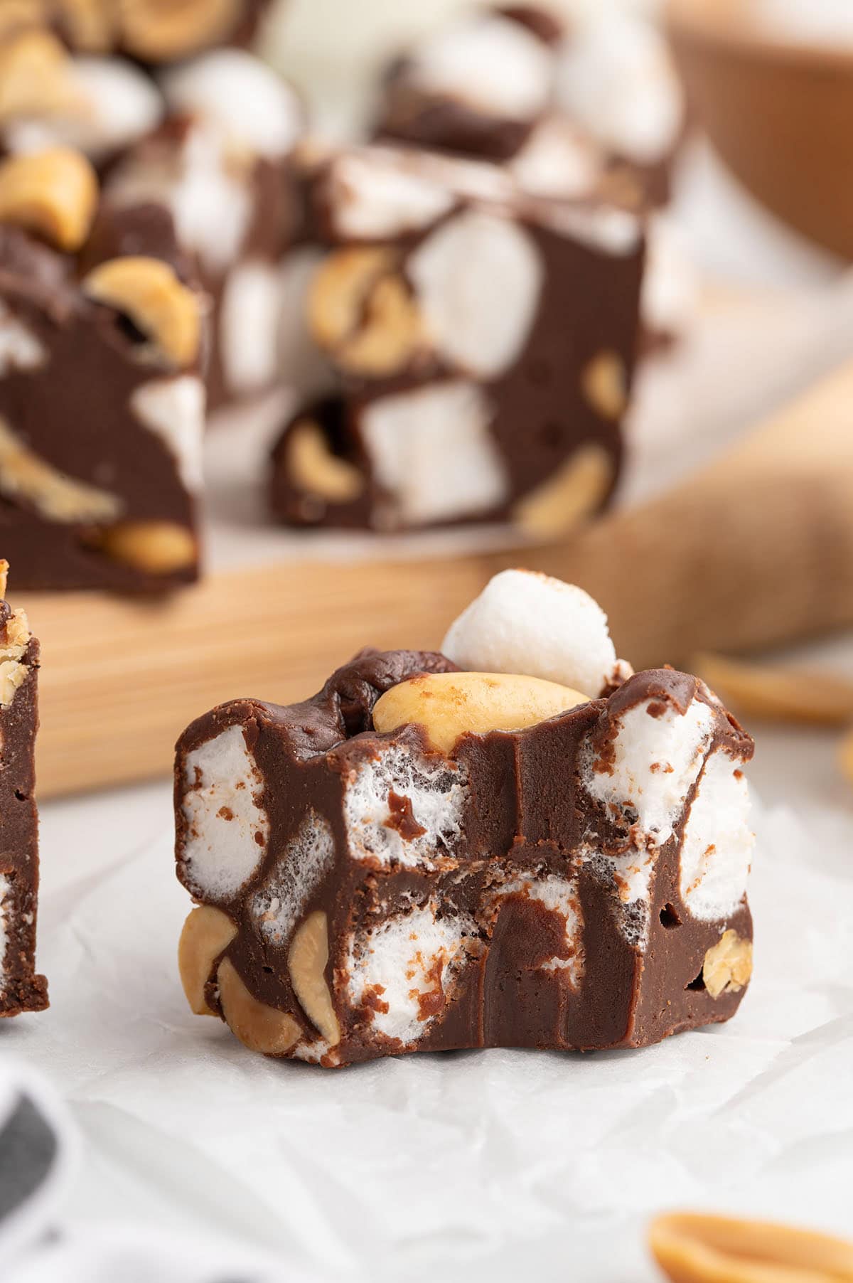 Close-up of a Rocky Road Fudge square filled with fluffy mini marshmallows and crunchy peanuts in rich chocolate fudge.