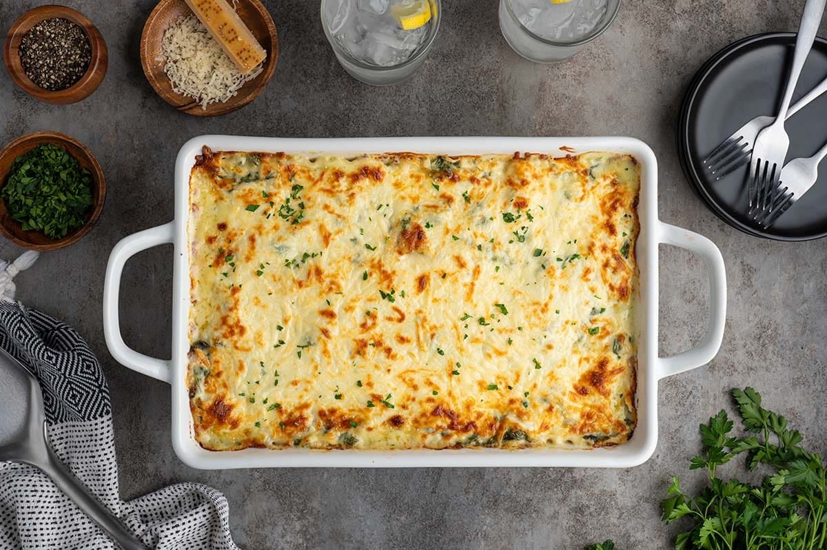 Bake until the cheese is melted, bubbly, and lightly golden on top. Let the lasagna rest for 10–15 minutes before slicing, then garnish with fresh parsley and serve.