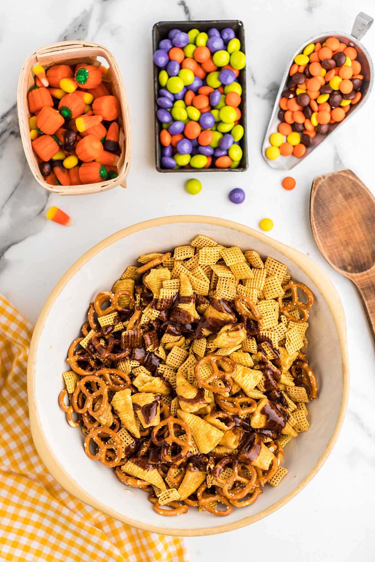 Chex mix and pretzels drizzled with seasoning sauce in a bowl.