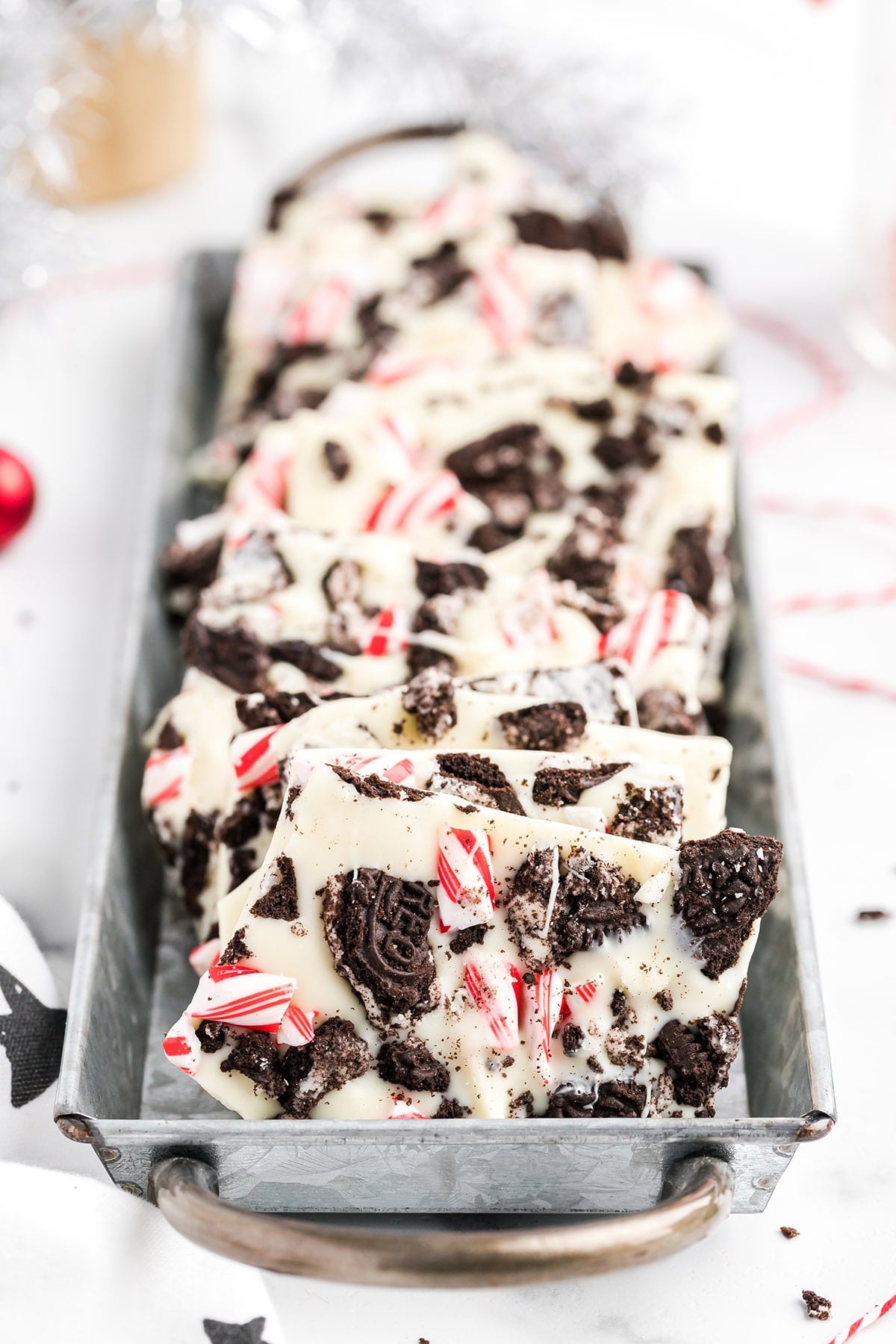 Pieces of Oreo peppermint bark with candy cane bits in a metal tray.