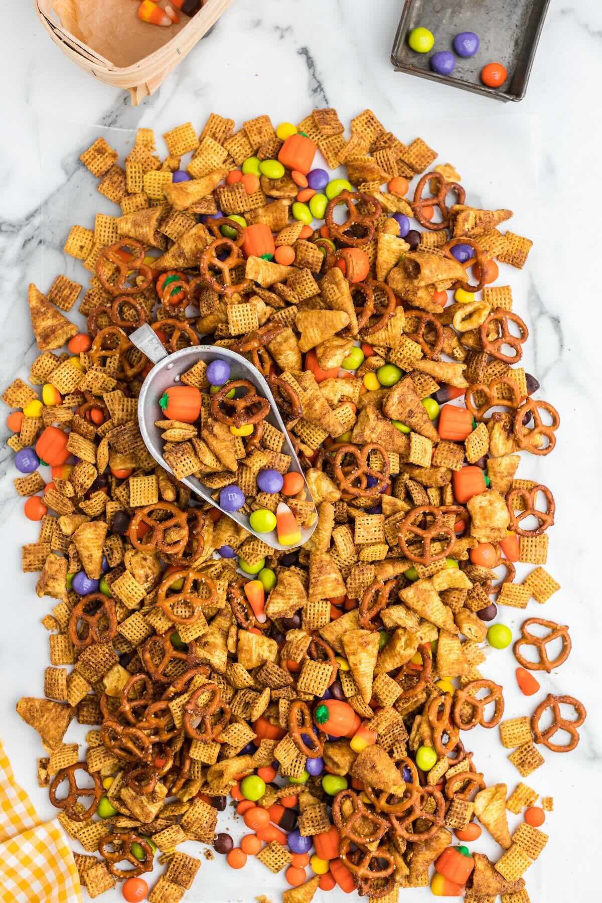 Pumpkin spice snack mix with candy corn and M&Ms on a table.