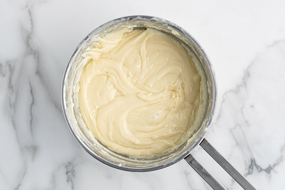 Melted white chocolate fudge base in a saucepan, ready to be divided and colored.