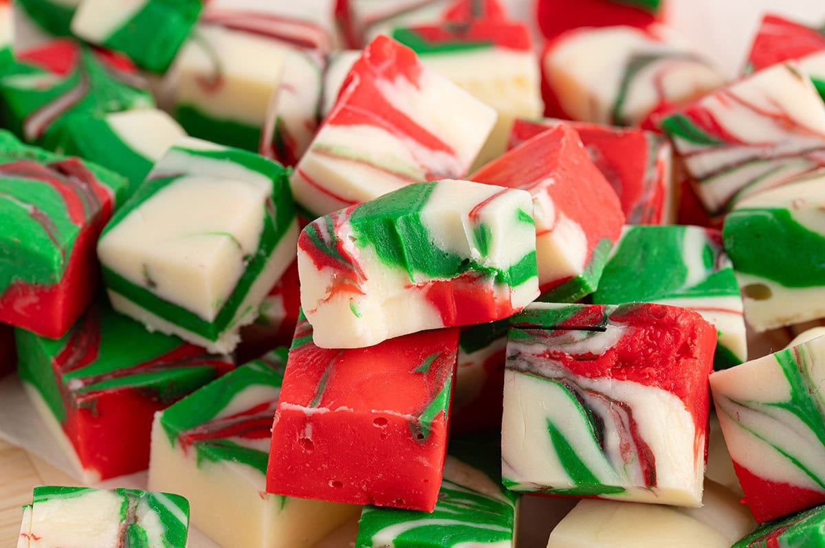 Close-up of a pile of red, green, and white swirled Christmas fudge pieces.