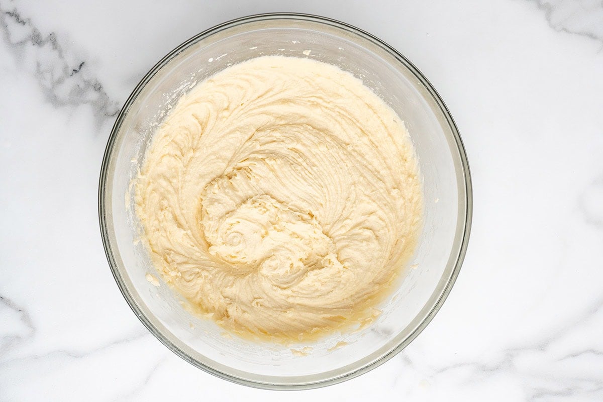 Creamy cake batter mixed in a glass bowl.