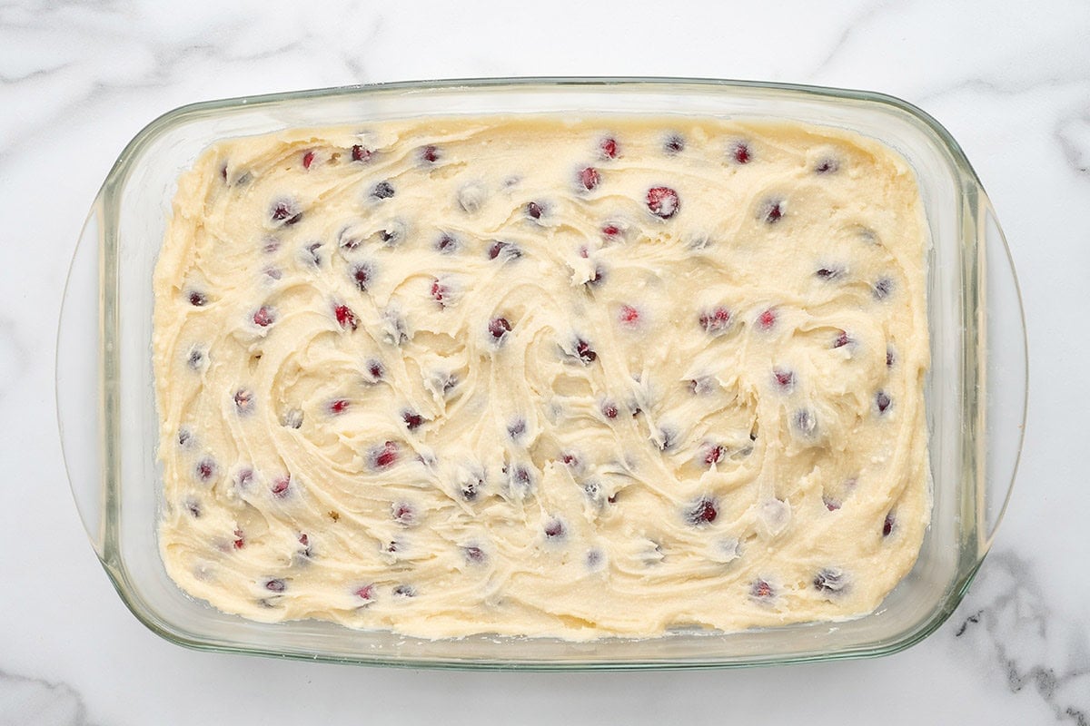 Cranberry cake batter spread in a baking dish.