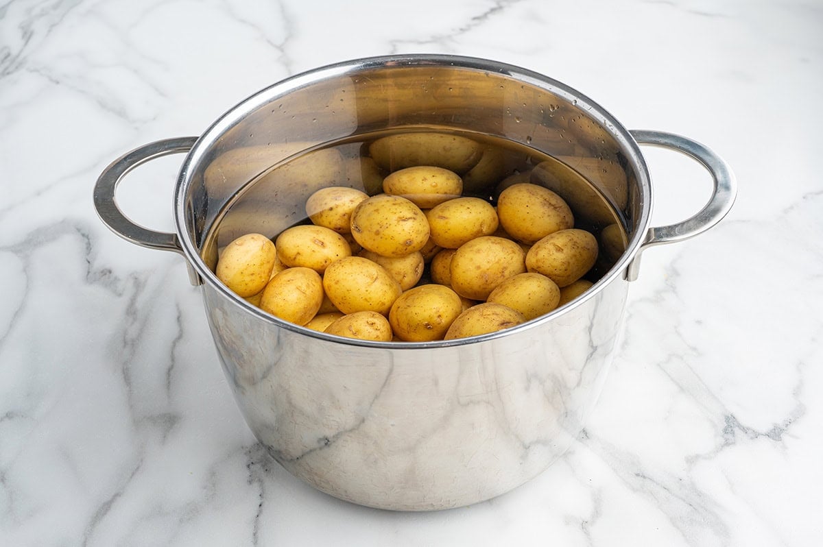Baby potatoes boiling in a pot of water.
