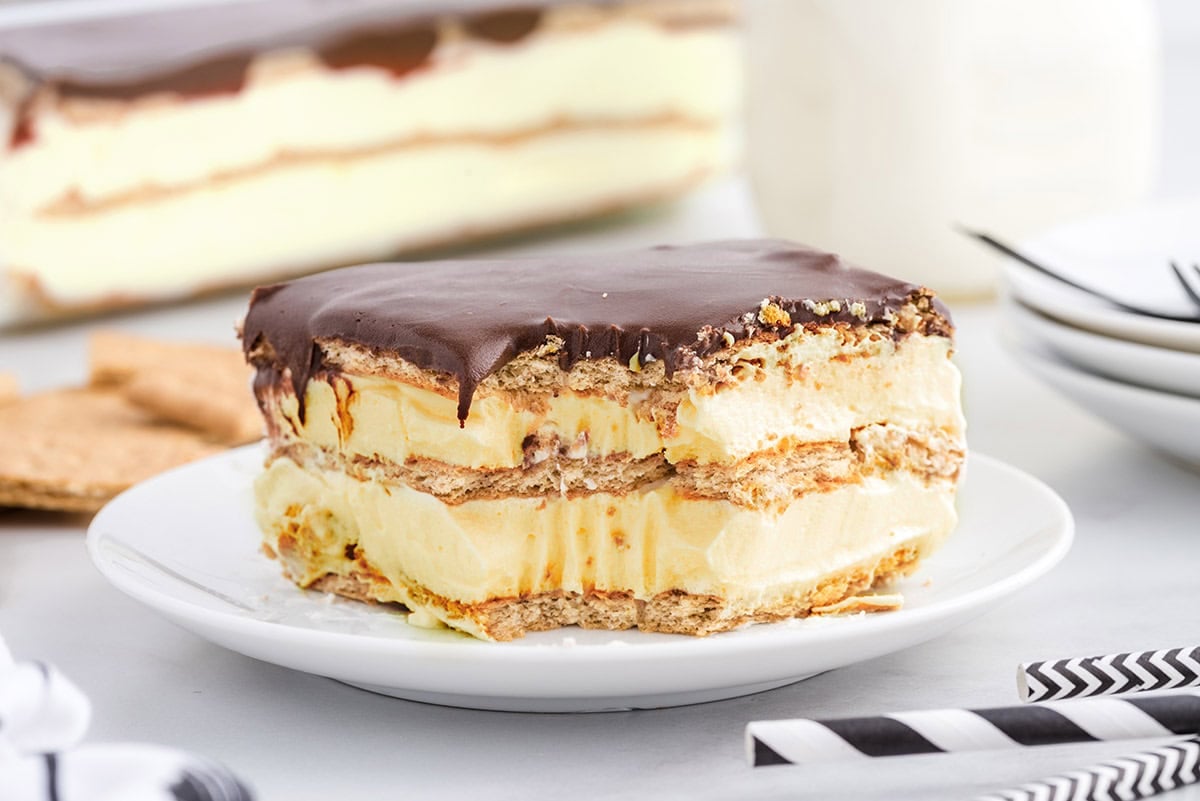 Close-up of a single slice of eclair cake with visible cream and graham cracker layers.