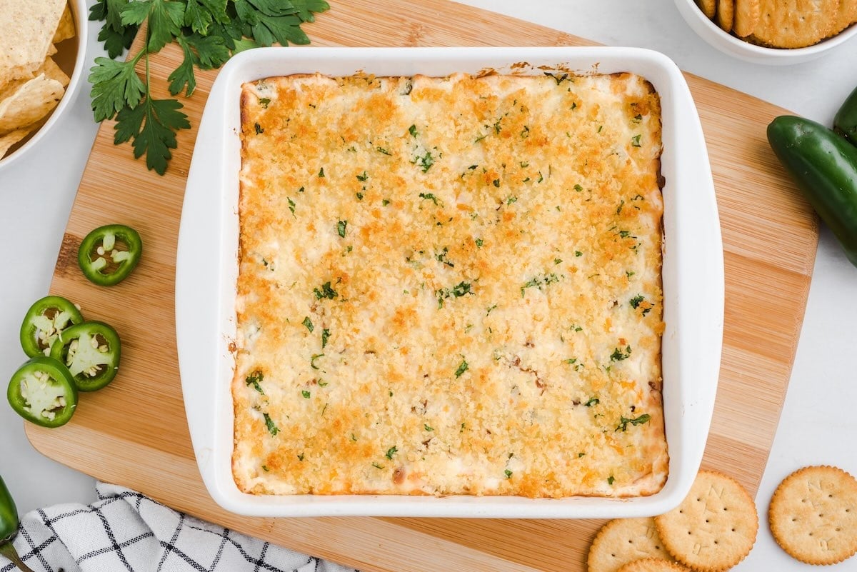 Overhead view of baked jalapeño popper dip on a cutting board.