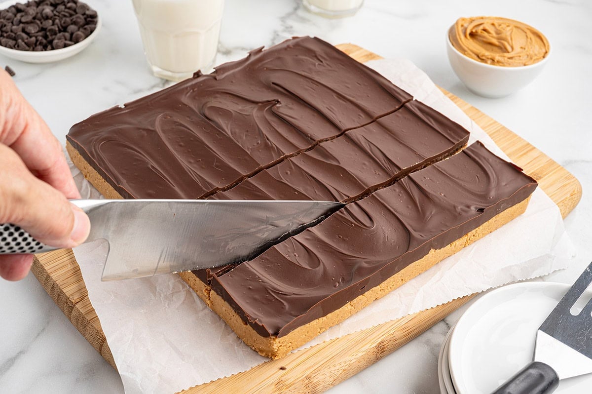 cut the peanut butter bars on top of wooden board. 