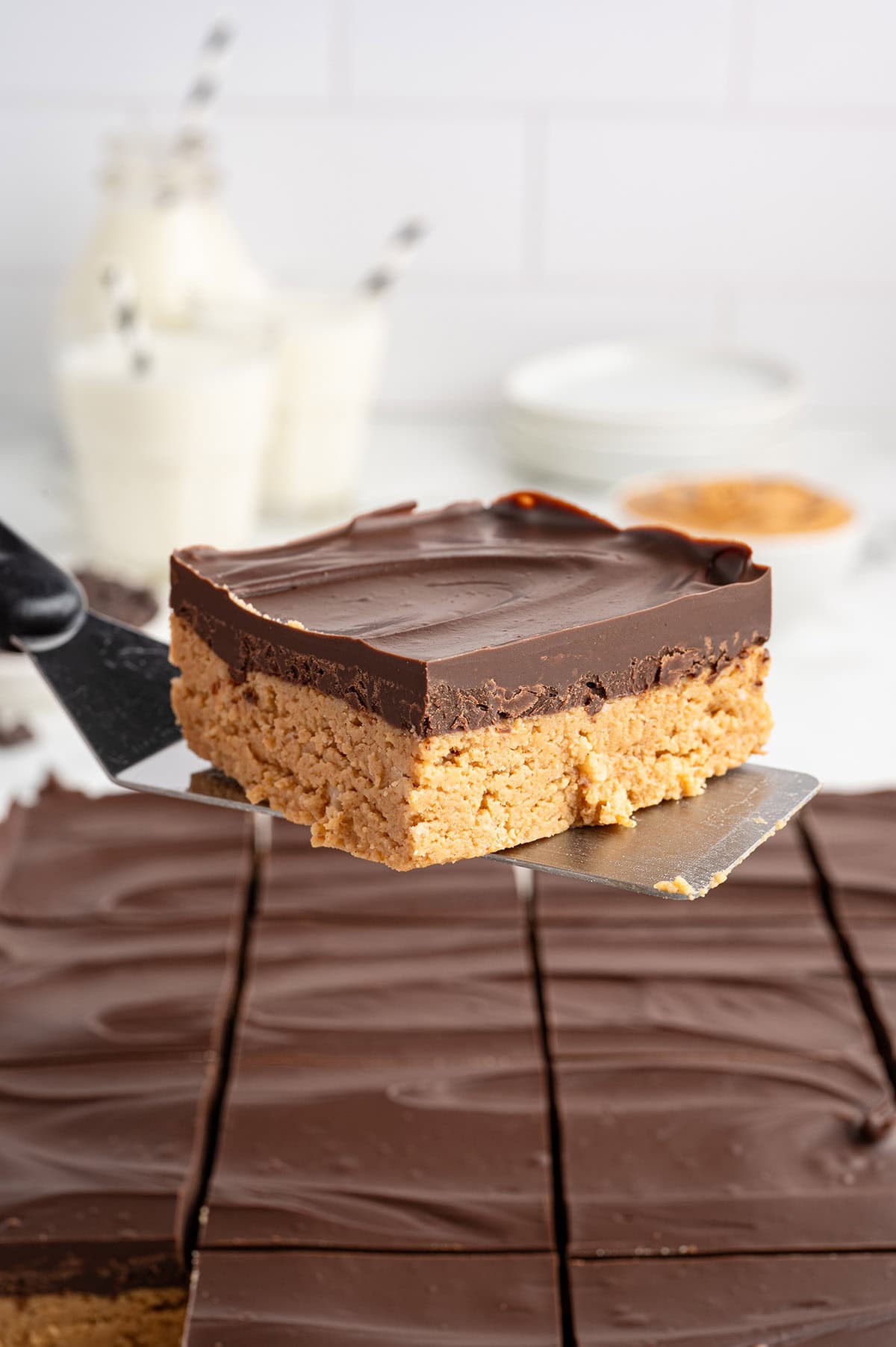 a slice of peanut butter is lifted up using spatula. 