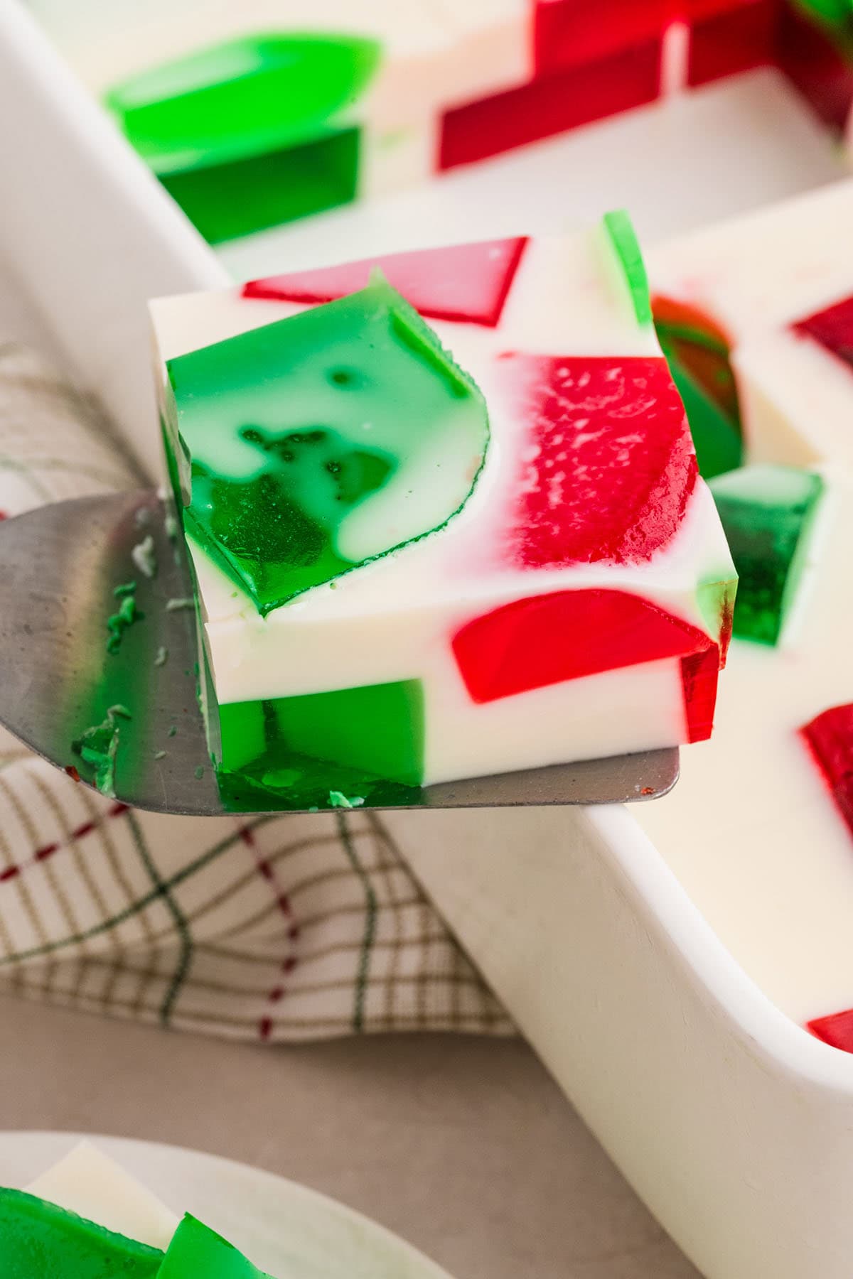 Red, green, and white Christmas Jello square on a spatula.