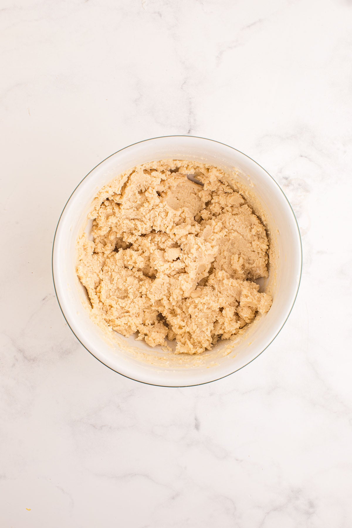 Sugar cookie dough in a white mixing bowl.