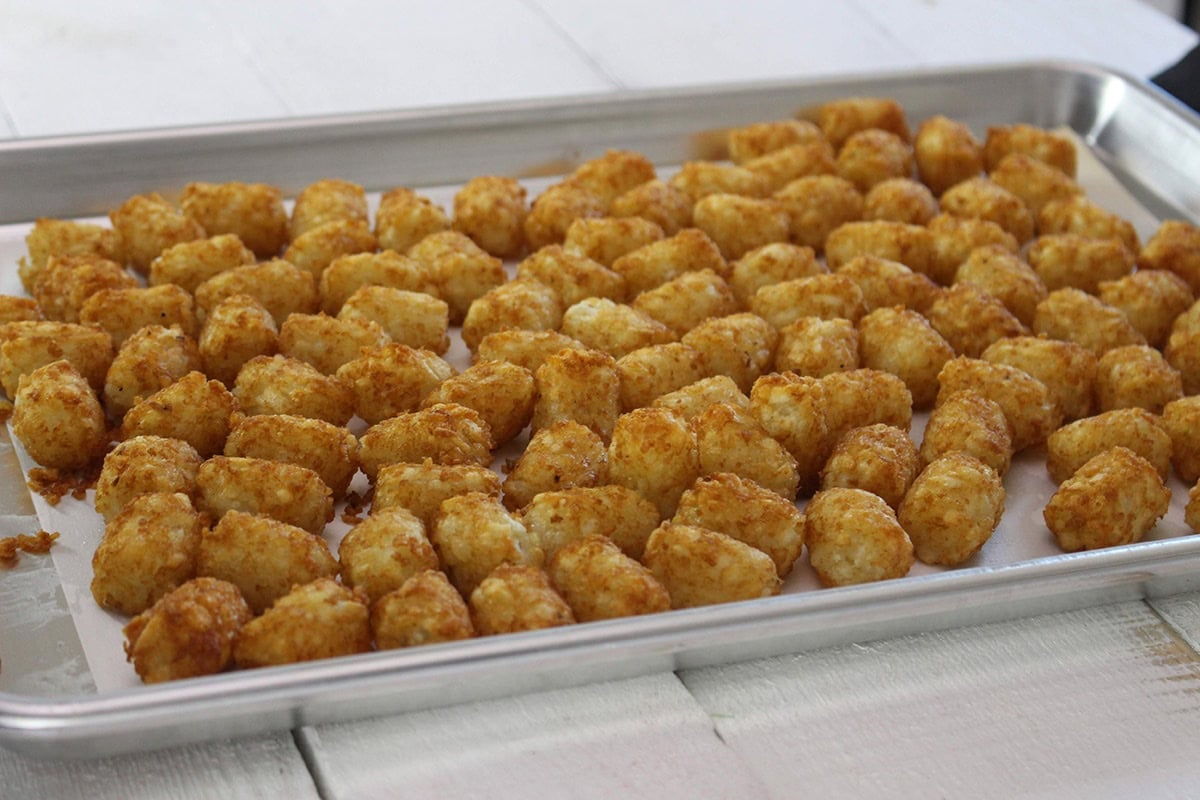 Crispy tater tots arranged on a baking sheet.