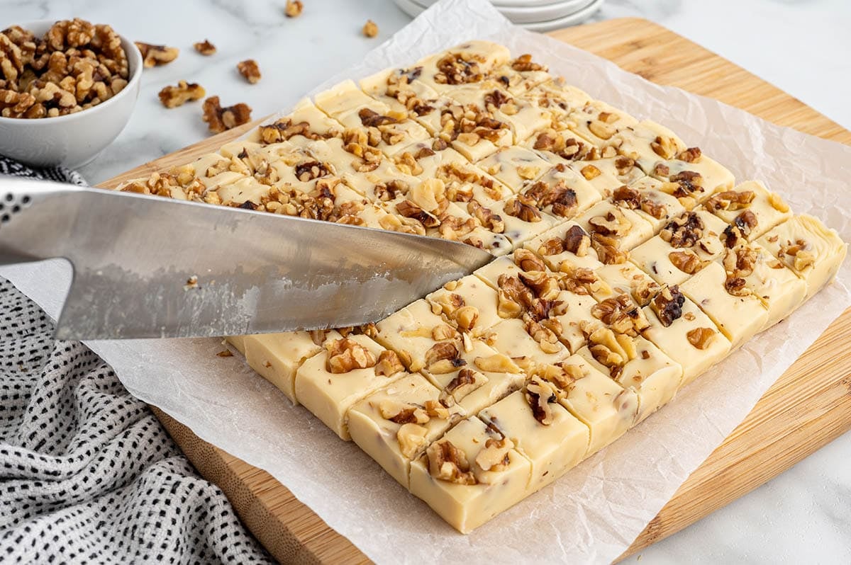 Maple walnut fudge being cut into squares.