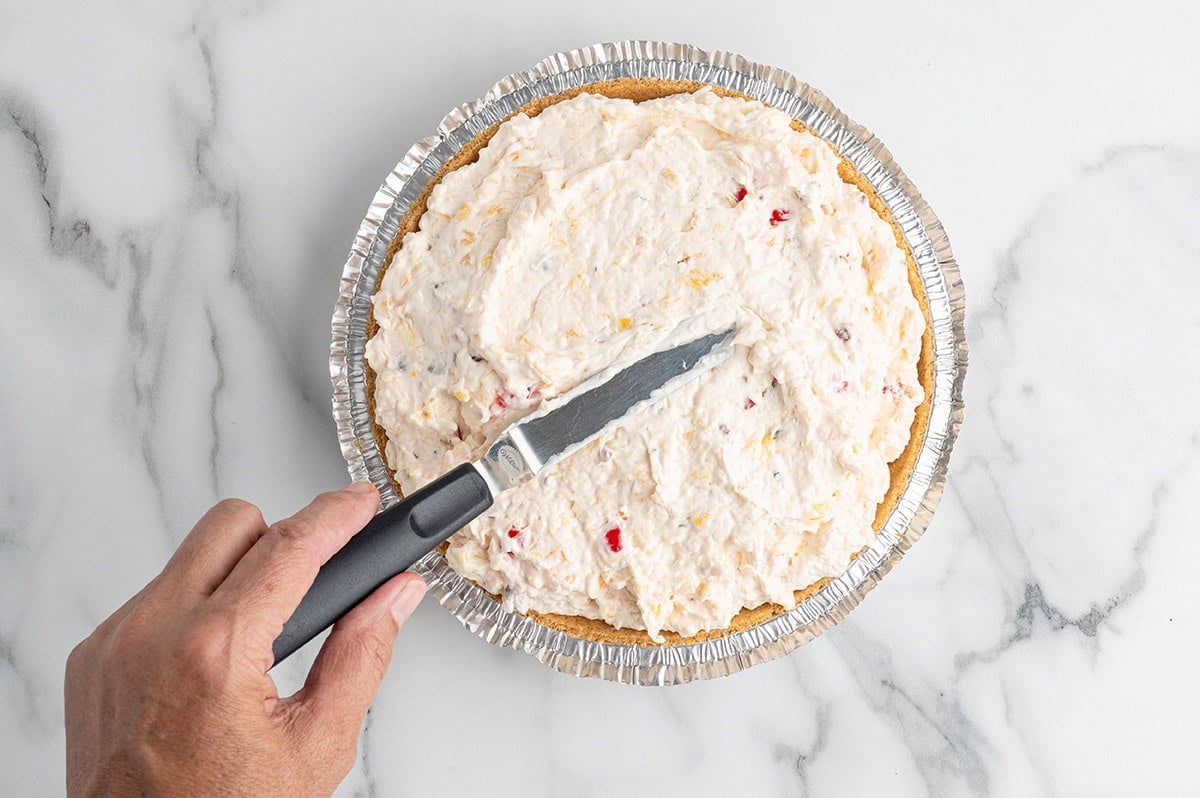 Creamy millionaire pie filling spread into a graham cracker crust.