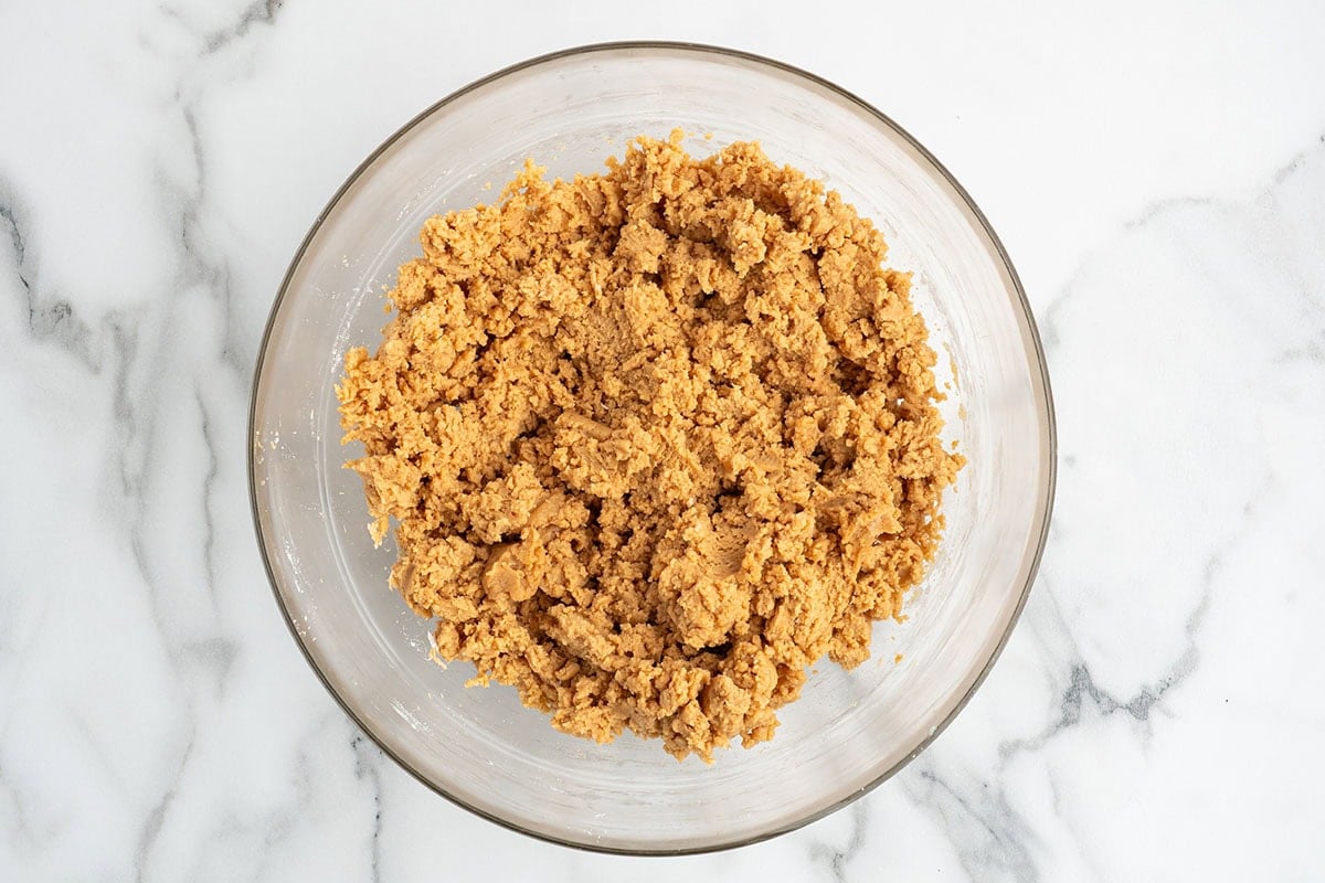 Peanut butter cheese ball mixture in a glass bowl before shaping.